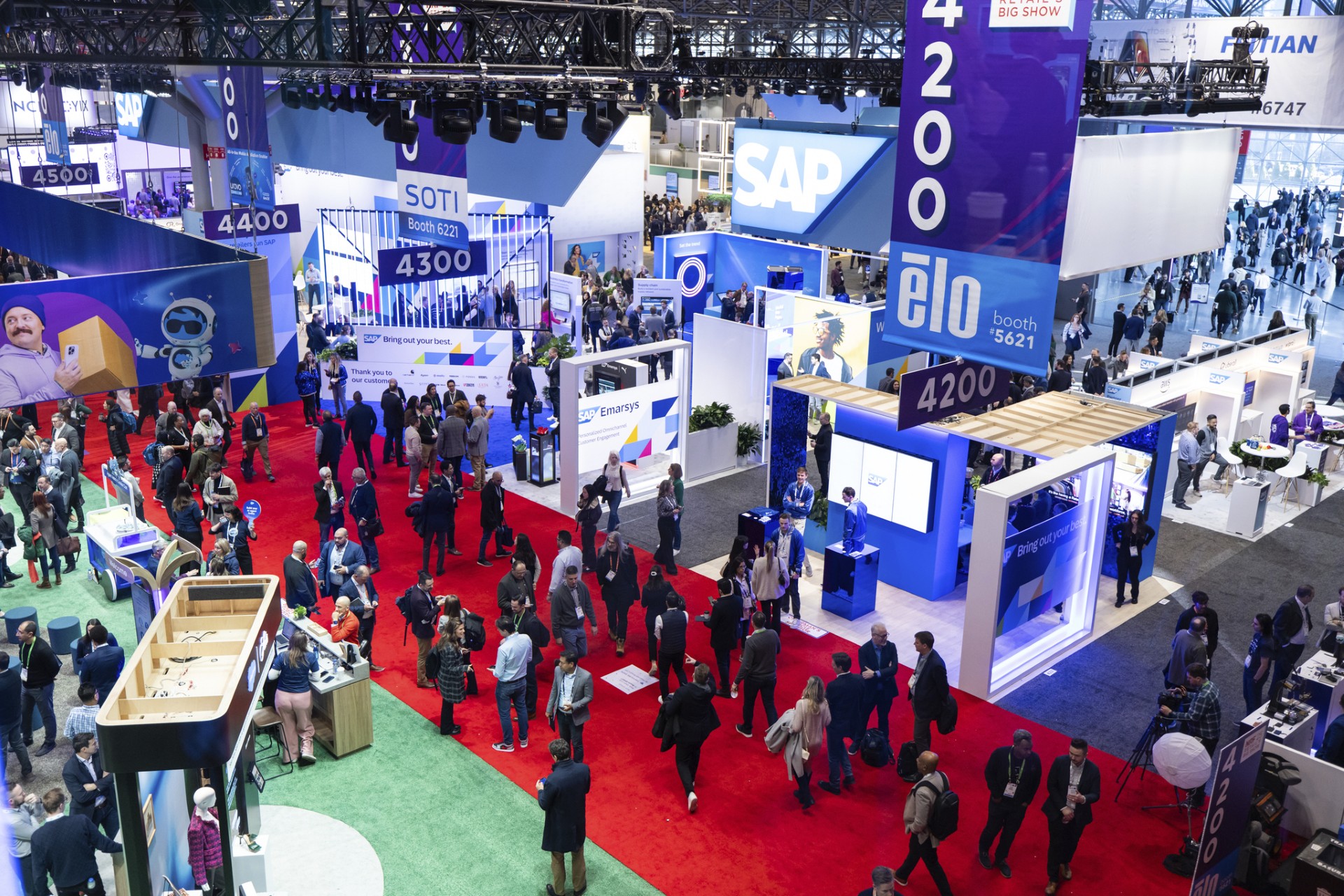 Vista elevada do piso da NRF Retail’s Big Show 2025, com pavilhões e visitantes.